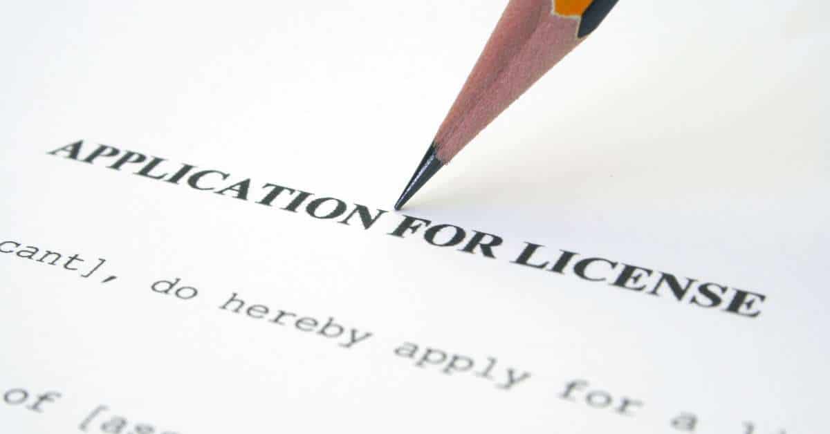 the tip of a pencil pointing at a zoomed in "application for license" paper document