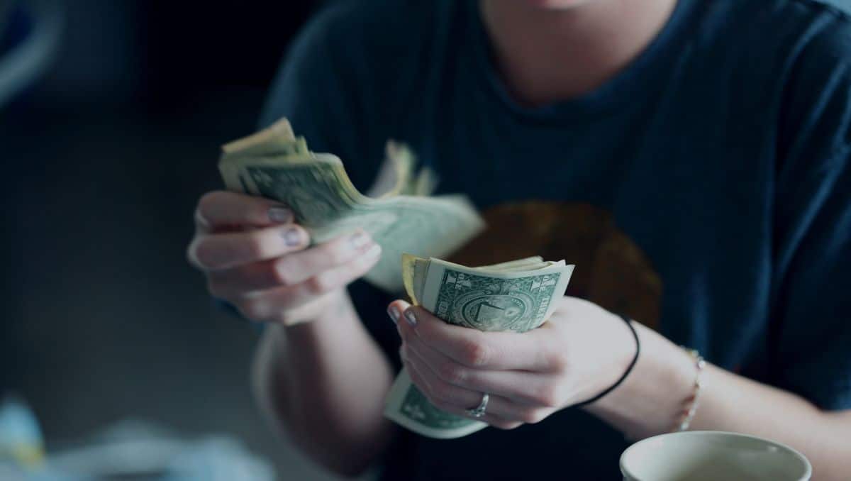 A woman counting dollars of cash.