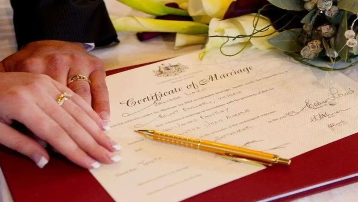 A new couple signing their Certificate of Marriage.