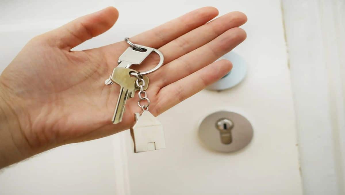 A hand holding a set of keys to the new apartment.
