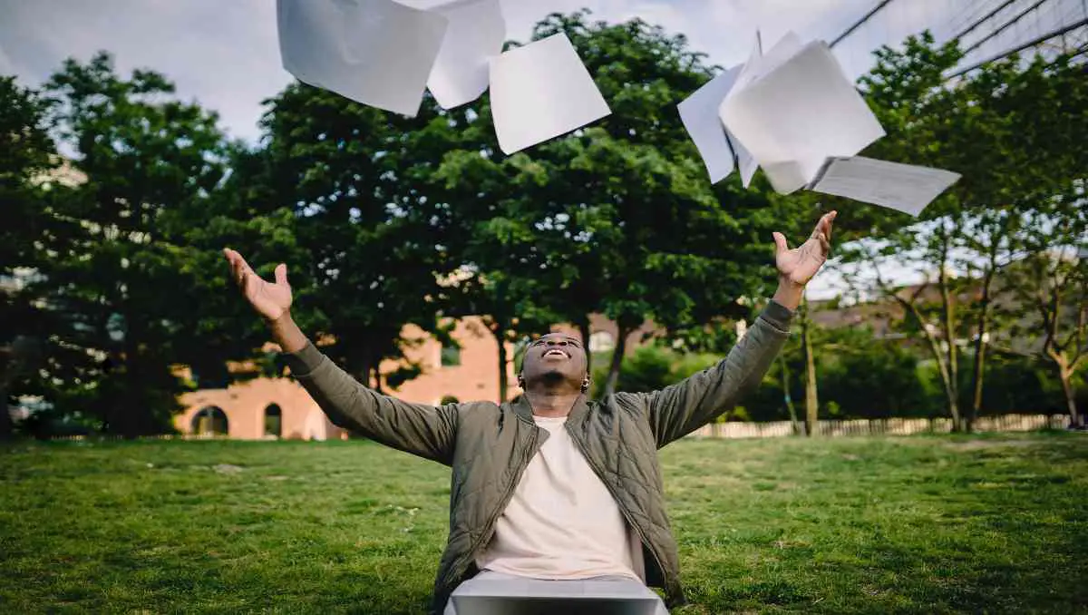 A man throwing papers in the air.